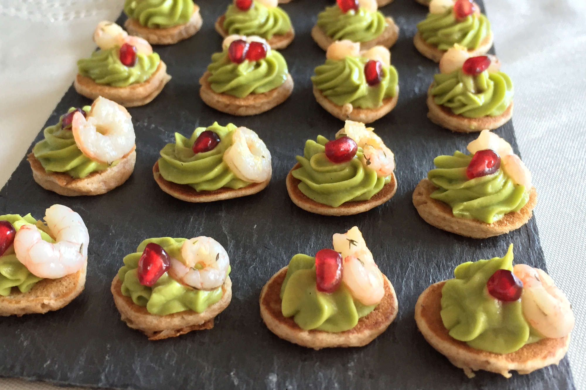 Fotografía de varios Blinis con Crema de Aguacate y Gambas sobre una bandeja